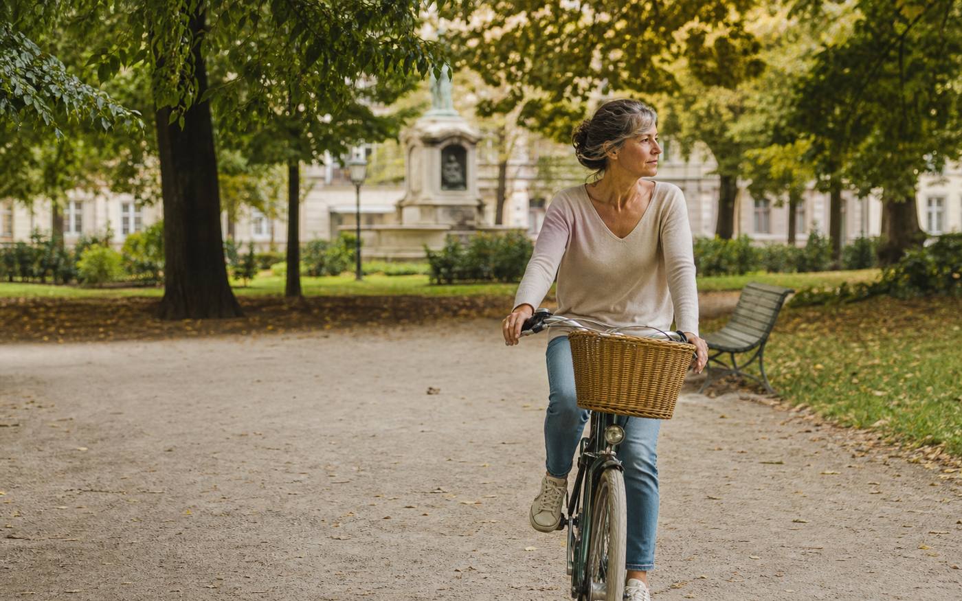 Mulher a andar de bicicleta num parque urbano